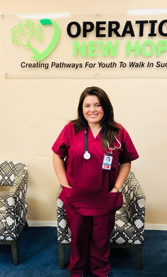 CNA graduate in scrubs at Operation New Hope