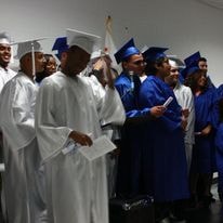 Graduates in blue and white caps and gowns