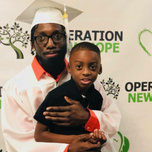 Graduate with son at Operation New Hope ceremony