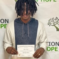 Quinton holding his certificate at Operation New Hope graduation 2023