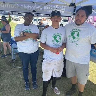 Students in South Bay Earth Day shirts at community event tent