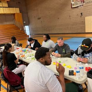 Students and staff doing an indoor hands-on activity at a community event